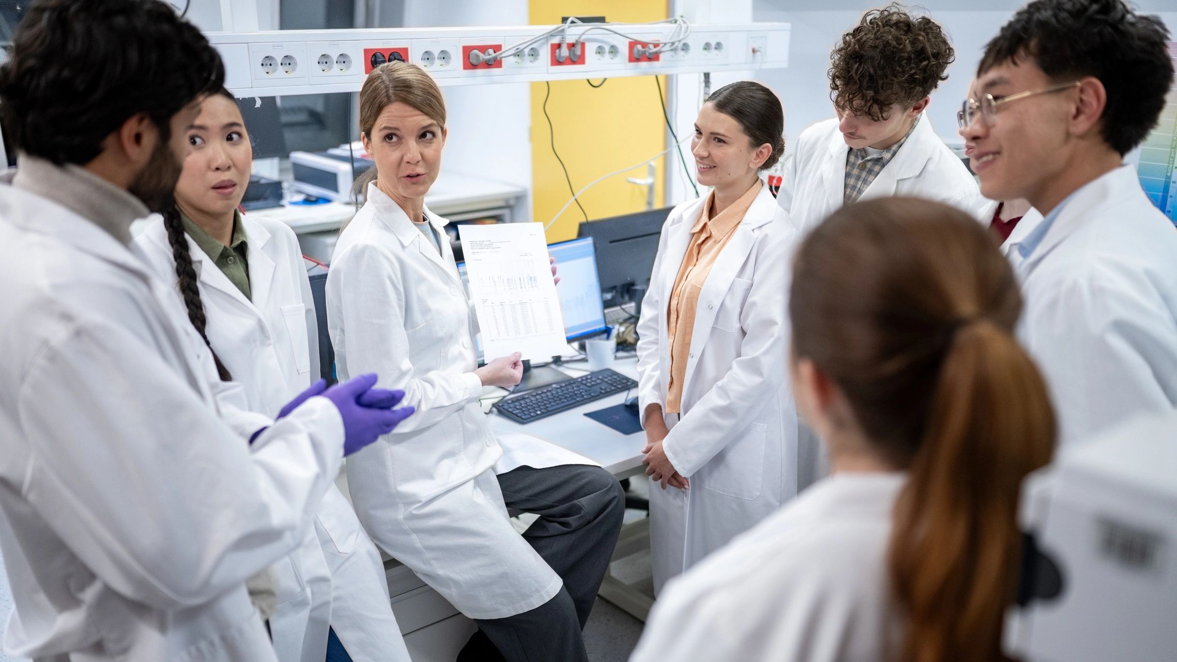 Graduate researchers discussing findings in a laboratory